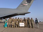 The crew of the 433rd Airlift Wing C-5M Super Galaxy "Reach 281" and others pose May 5 at the airport in New Delhi, India.