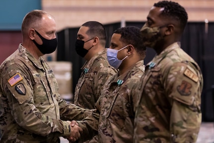 U.S. Army Col. Robert Hughes, commander of Task Force Iron Guard, congratulates Staff Sgt. Nestor Rivas, Staff Sgt. Lavone Graham, and Senior Airman Solomon Stirling, all with the New Jersey Air National Guard’s 108th Security Forces Squadron, who were honored in Atlantic City May 17, 2021, for helping prevent a man from killing himself in April.