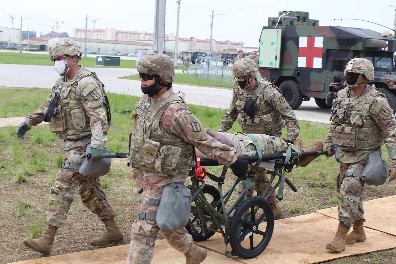 Medics haul stretcher during mock casualty exercise.