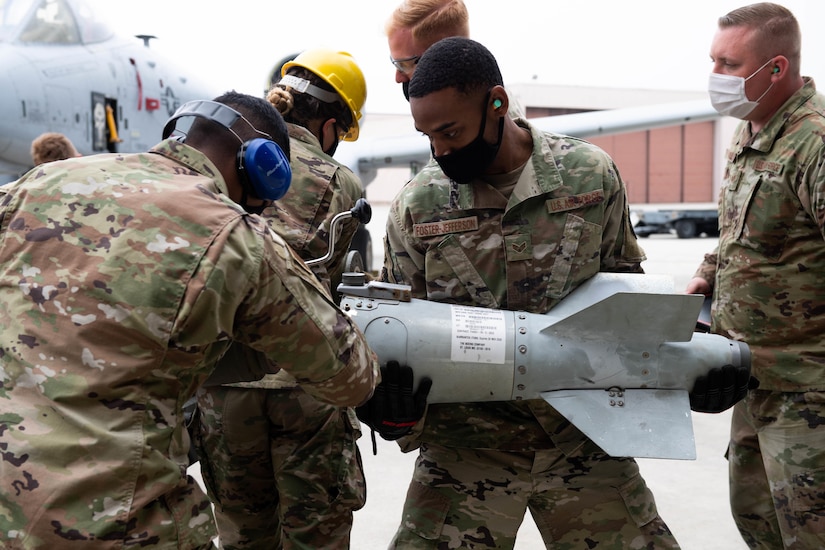 Troops load rocket into launcher.