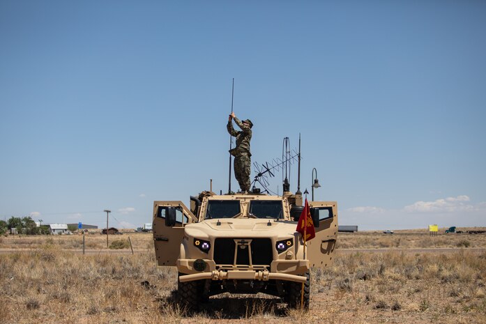 U.S. Marine Corps Lance Cpl. Nathan Taylor, a field radio operator, stands on top of a joint light tactical vehicle and secures an antenna in Holbrook, Arizona, May 13, 2021.  Marines with 2nd Transportation Battalion, Combat Logistics Regiment 2, 2nd Marine Logistics Group conducted a convoy across the United States starting in Camp Lejeune, North Carolina and arriving at Marine Corps Air Ground Combat Center Twentynine Palms, California, in one of the longest convoys in recent Marine Corps history. (U.S. Marine Corps photo by Lance Cpl. Scott Jenkins)