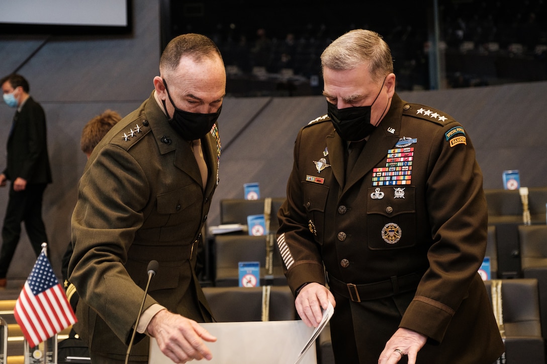 Two men in military uniforms speak.