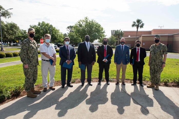 Rear Adm. Kevin Byrne, commander of the Naval Sea Systems Command Warfare Centers, along with Capt, David Back, commanding officer at NSWC PCD, presented letters of appreciation and challenge coins to a Quickstrike 64 Extended Range team of seven individuals for receiving the Joint Capability Technology Demonstration Team of the Year Award during a ceremony May 18. Pictured from left to right: Rear Adm. Kevin Byrne, Ken Ford, John Sojdohei, Jomo Martin, Tim Pham, Bill Vandiver, Sasha Dastgerdi, Capt. David Back. Not pictured: Tom Frederick