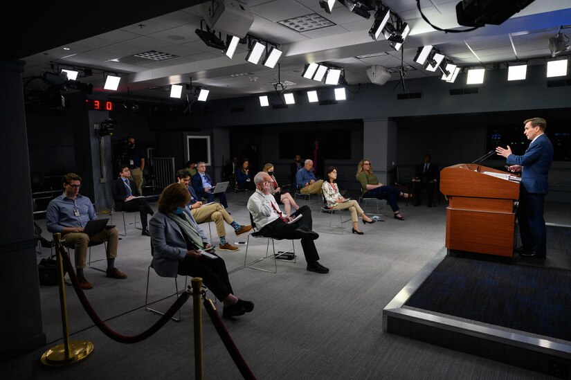 A man answers reporters questions during a press briefing.