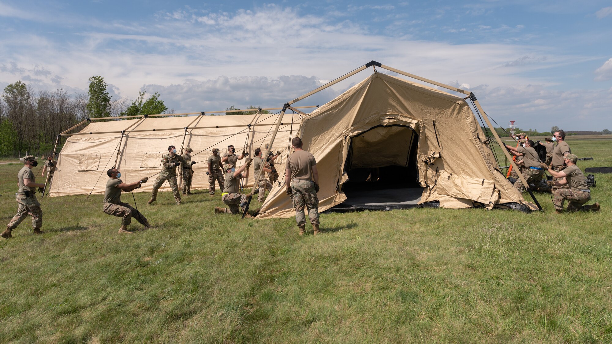 A group of Airmen setting up a large tent.