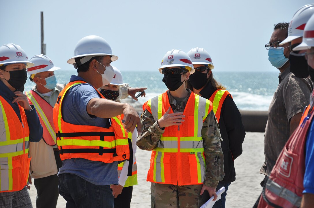 U.S. Army Corps of Engineers Los Angeles District commander Col. Julie Balten consults with members of her team and contractors, April 12, on Oceanside Beach, California. The annual maintenance dredging of Oceanside Harbor is contracted and supervised by the U.S. Army Corps of Engineers Los Angeles District.