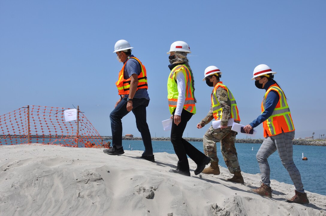 U.S. Army Corps of Engineers Los Angeles District commander Col. Julie Balten with two members of her team, follow a contractor into the construction zone at the mouth of Oceanside Harbor, April 12. Sand dredged from the harbor will be piped to a section of Oceanside Beach, California. The annual maintenance dredging of Oceanside Harbor is contracted and supervised by the U.S. Army Corps of Engineers Los Angeles District.