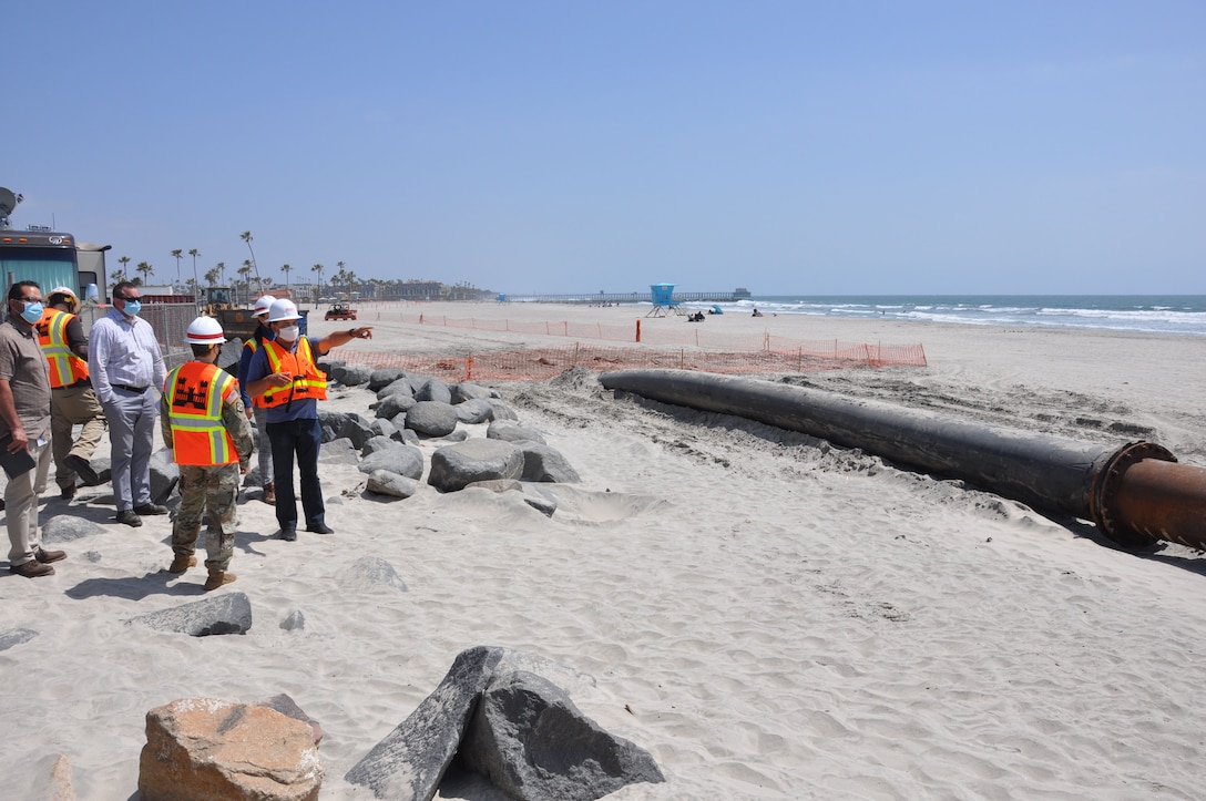 U.S. Army Corps of Engineers Los Angeles District commander Col. Julie Balten and Oceanside city officials, listen to a briefing by a Manson Construction contractor, April 12, at the mouth of Oceanside Harbor. Sand dredged from the harbor will be piped to a section of Oceanside Beach, California. The annual maintenance dredging of Oceanside Harbor is contracted and supervised by the U.S. Army Corps of Engineers Los Angeles District.