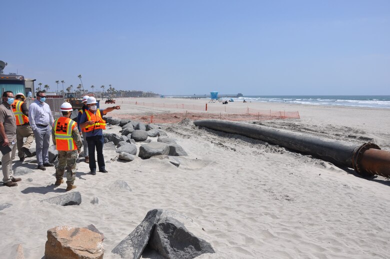 U.S. Army Corps of Engineers Los Angeles District commander Col. Julie Balten and Oceanside city officials, listen to a briefing by a Manson Construction contractor, April 12, at the mouth of Oceanside Harbor. Sand dredged from the harbor will be piped to a section of Oceanside Beach, California. The annual maintenance dredging of Oceanside Harbor is contracted and supervised by the U.S. Army Corps of Engineers Los Angeles District.