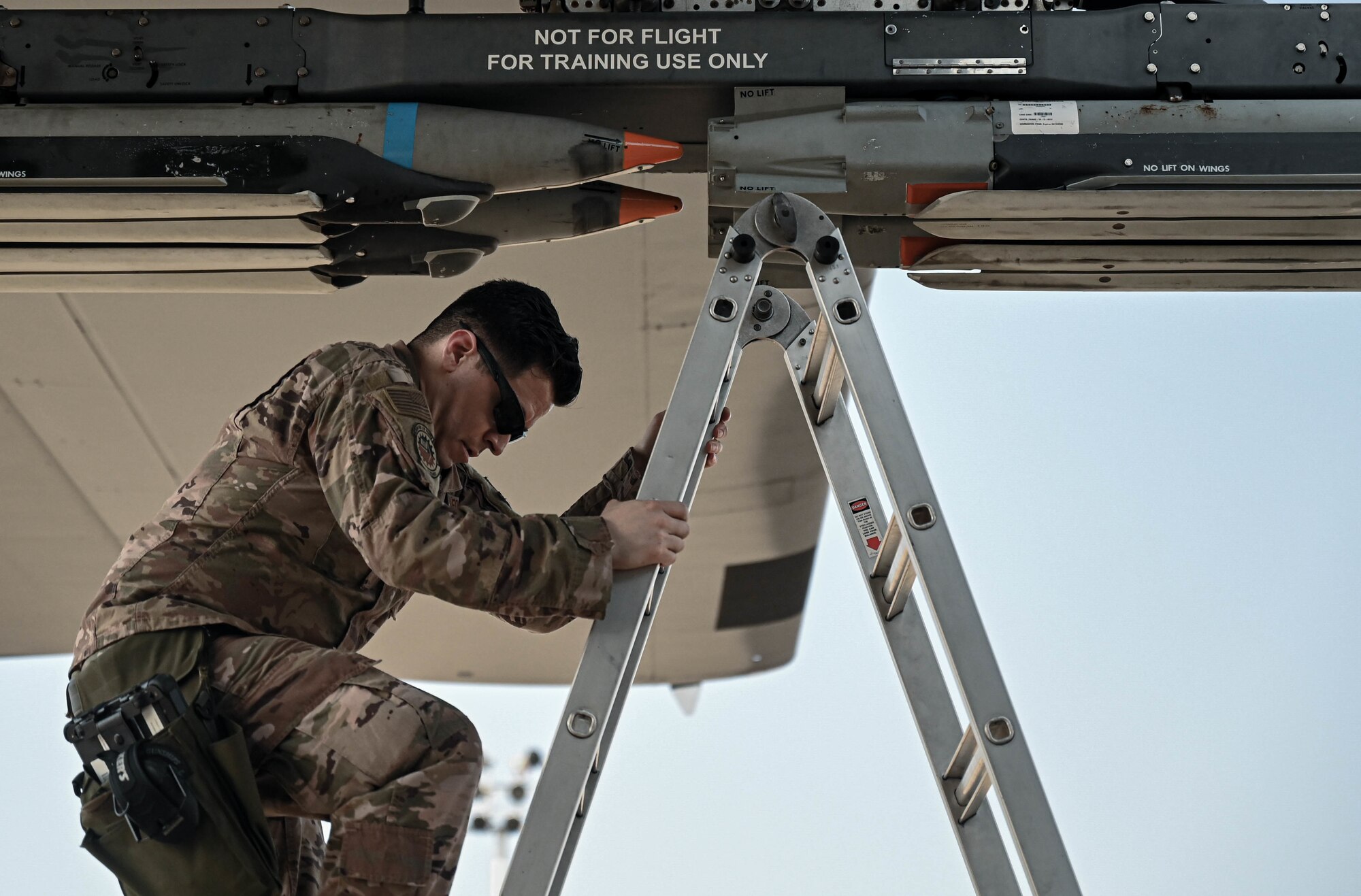 U.S. Air Force Staff Sgt. Daniel Buruato, a weapons load crew chief with the 4th Aircraft Maintenance Unit, dismounts from a ladder.