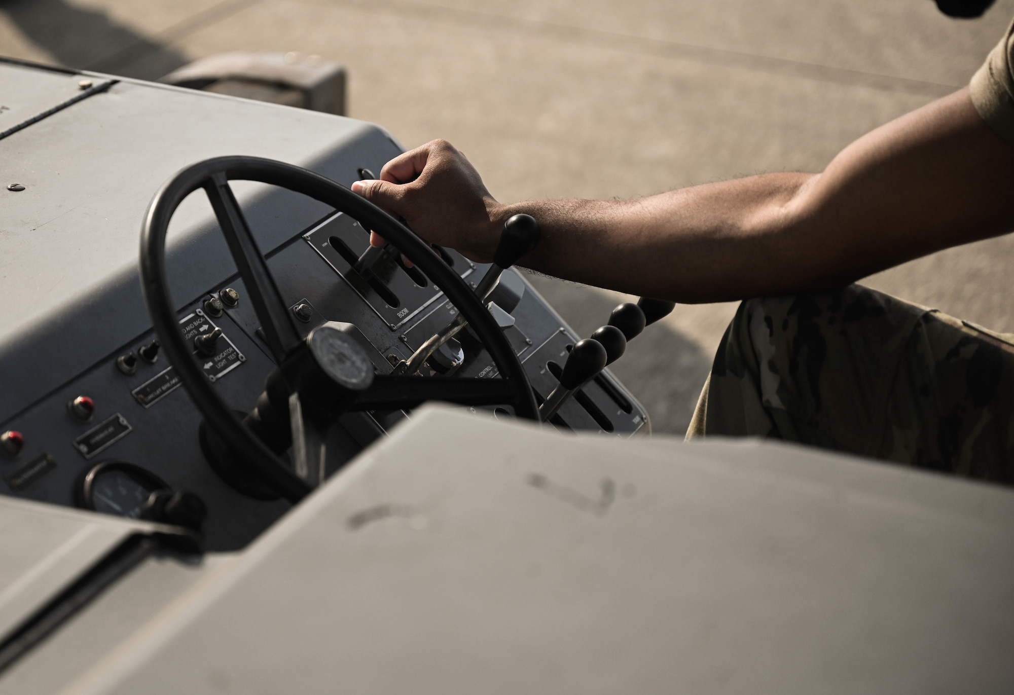U.S. Air Force Airman 1st Class Michael Slaughter, a weapons load crew member with the 4th Aircraft Maintenance Unit, operates machinery while delivering a guided bomb unit to an AC-130W Stinger II gunship.
