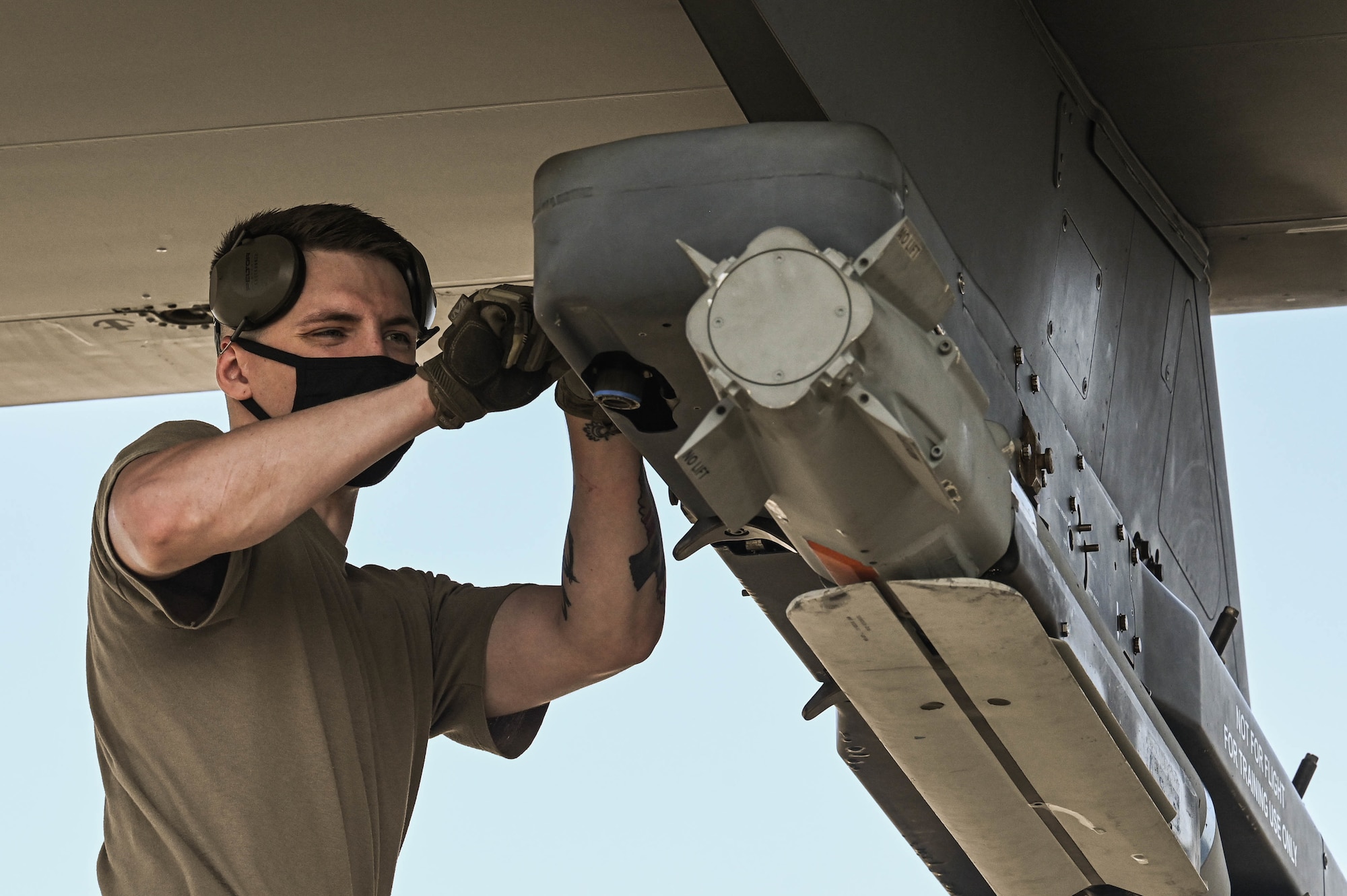 U.S. Air Force Senior Airman Paul Seagraves, a weapons load crew member with the 4th Aircraft Maintenance Unit, secures a guided bomb unit to an AC-130W Stinger II gunship.