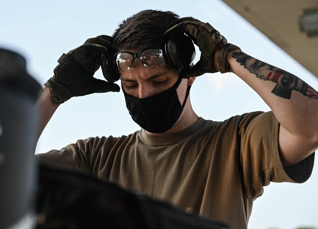 U.S. Air Force Senior Airman Paul Seagraves, a weapons load crew member with the 4th Aircraft Maintenance Unit, adjusts his personal protection equipment.