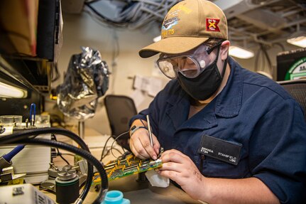 Electronics Technician Seaman Amanda Stansfield, from Waverly, New York, uses a soldering tool on a controller circuit card in a systems workshop aboard the Nimitz-class aircraft carrier USS Harry S. Truman (CVN 75) during sea trials after completing an extended carrier incremental availability.