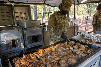 New York Army National Guard Spc. Fatima S. Edwards, assigned to Headquarters and Headquarters Company, 101st Expeditionary Signal Battalion, cooks chicken during training for the next Philip A. Connelly Competition at Joint Base McGuire-Dix-Lakehurst, N.J., May 15, 2021. The competition provides recognition for excellence in the preparation and serving of food in Army troop dining facilities and field kitchens.