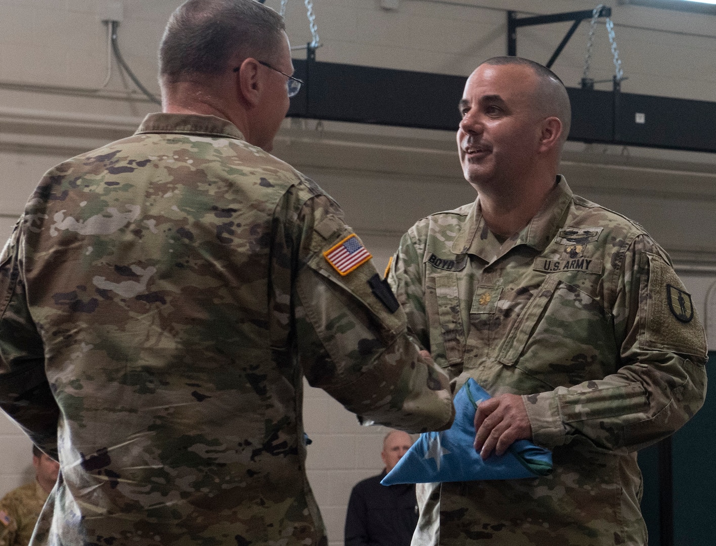 Maj. Jasen Boyd, commanding officer for Task Force Mansfield, receives a Vermont battle flag from Maj. Gen. Greg Knight, the state’s adjutant general, during a sendoff ceremony at Camp Johnson, Vermont, May 18, 2021. The task force will deploy to the U.S. European Command area of responsibility for one year. (U.S. Army National Guard photo by Don Branum)