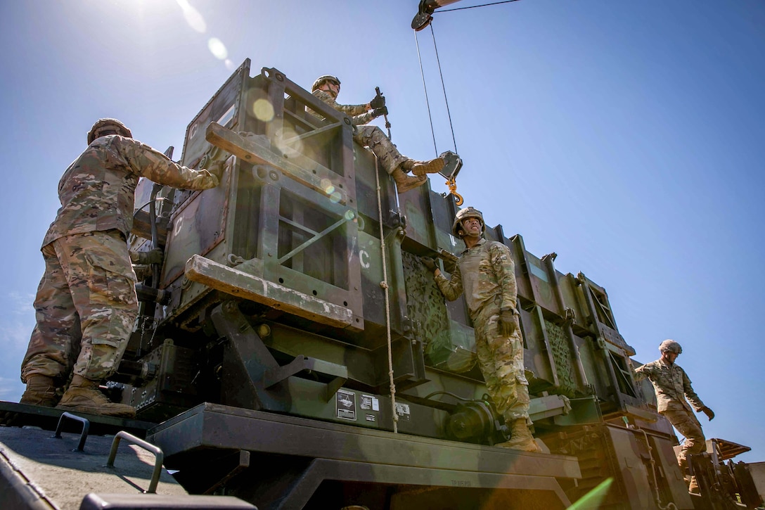 Soldiers work on a large missile launching station.