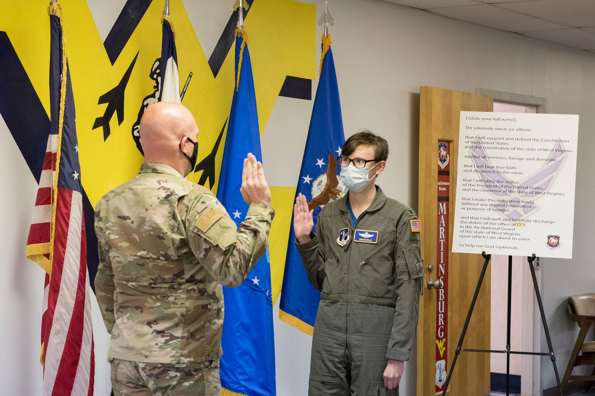 Hunter Willis is sworn in as commander of the 167th Airlift Wing by U.S. Air Force Col. Bill Annie, 167th Mission Support Group commander, during a commander for the day event at the 167th Airlift Wing, Martinsburg, West Virginia, May 13, 2021. Willis, a local area resident diagnosed with a terminal illness, was invited to the 167th to serve as the wing commander for the day. After he was sworn in as commander, Willis was mission briefed, flown on a C-17 Globemaster III aircraft training mission and promoted his father, Tom Willis, to Lieutenant Colonel. (U.S. Air National Guard photo by Senior Airman Edward Michon).