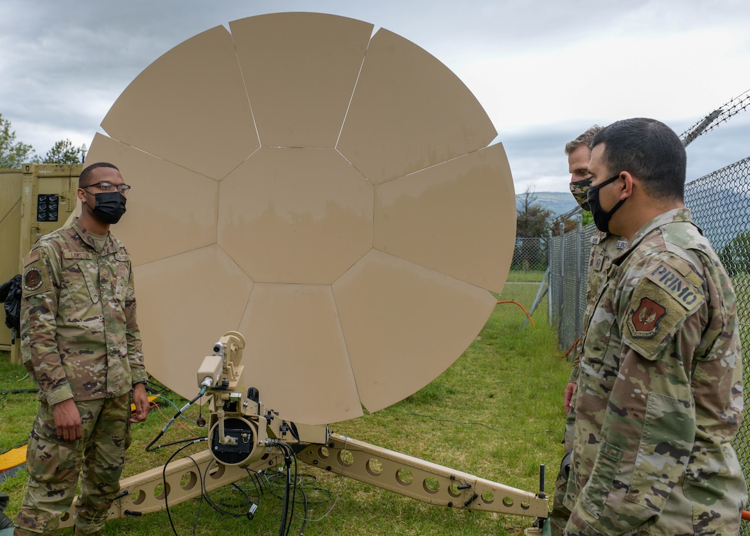 Tech. Sgt. Timothy Puente, 606th Air Control Squadron (ACS) tactical satellite communication (SATCOM) production supervisor, right, and Airman 1st Class Laderran Lawston, 606th ACS radio frequency technician, left, discuss the Airbus Ranger SATCOM terminal’s capabilities at Aviano Air Base, Italy, May 17, 2021. During Astral Knight 2021, the 606th ACS used the satellite to transmit data to forward-deployed locations in Slovenia and Croatia, enabling the controllers to control the airspace. (U.S. Air Force photo by Airman 1st Class Brooke Moeder)