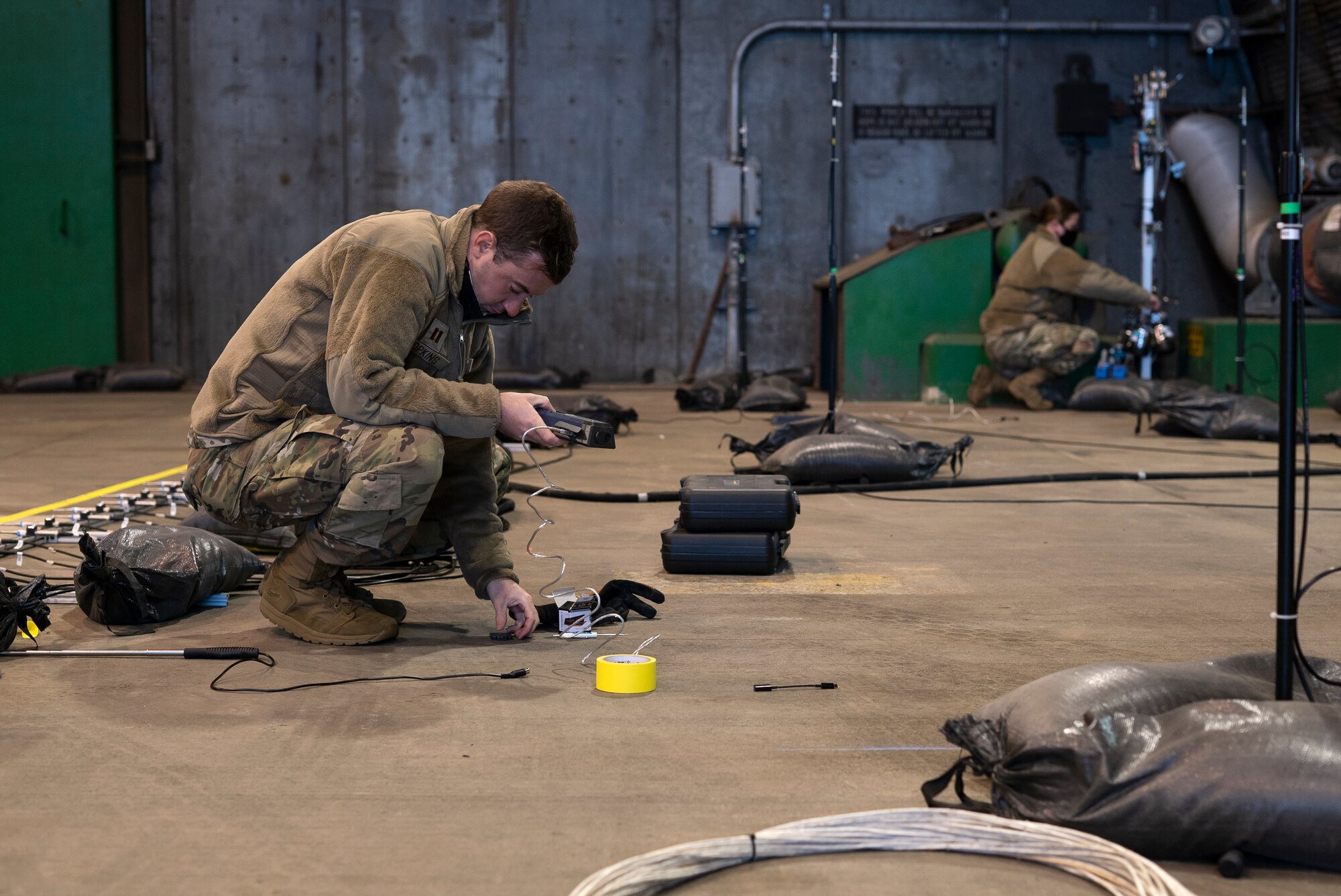 U.S. Air Force Capt. Christopher Hopkins, a systems sensory engineer and Tech Sgt. Katherine Harris, NCO in-charge of hazard recognition, both stationed at Wright-Patterson Air Force Base, Ohio, calibrate monitoring devices prior to an F-35A Lightning II acoustic and emission test at Royal Air Force Lakenheath, England, May 4, 2021. The data collected during testing will be used to ensure that the acoustic load inside the protective aircraft shelter is not exceeded, therefore preventing structural fatigue to the aircraft and ensuring a safe work environment. (U.S. Air Force photo by Senior Airman Jessi Monte)