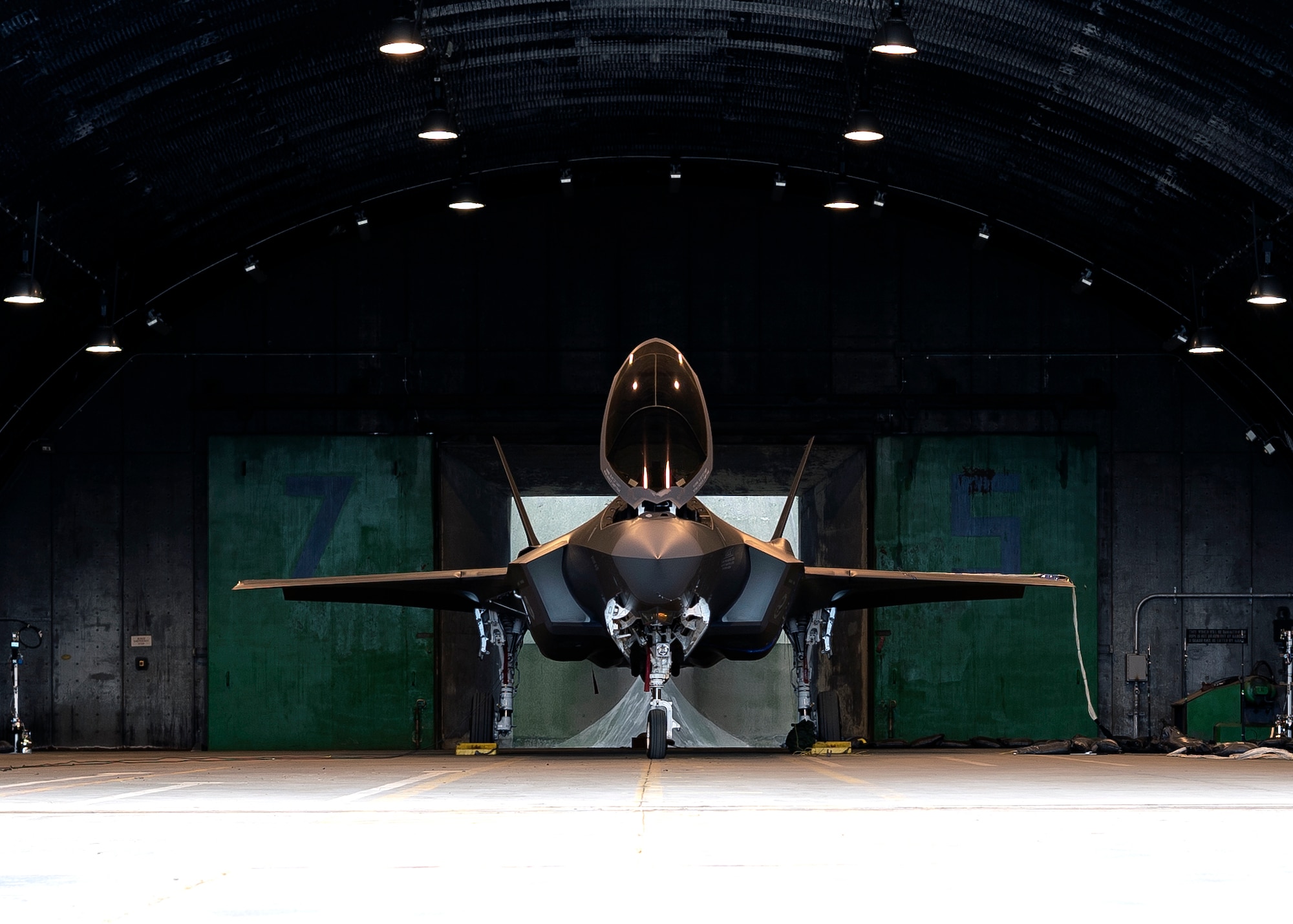 An F-35A Lightning II assigned to the 158th Fighter Wing Air, Vermont National Guard, stands static inside a protective aircraft shelter prior to the start of an acoustic and emission test at Royal Air Force Lakenheath, England, May 4, 2021. Prior to testing, acoustic sensors are affixed to the skin of the aircraft in structurally critical locations where acoustic pressure levels cannot be exceeded. (U.S. Air Force photo by Senior Airman Jessi Monte)