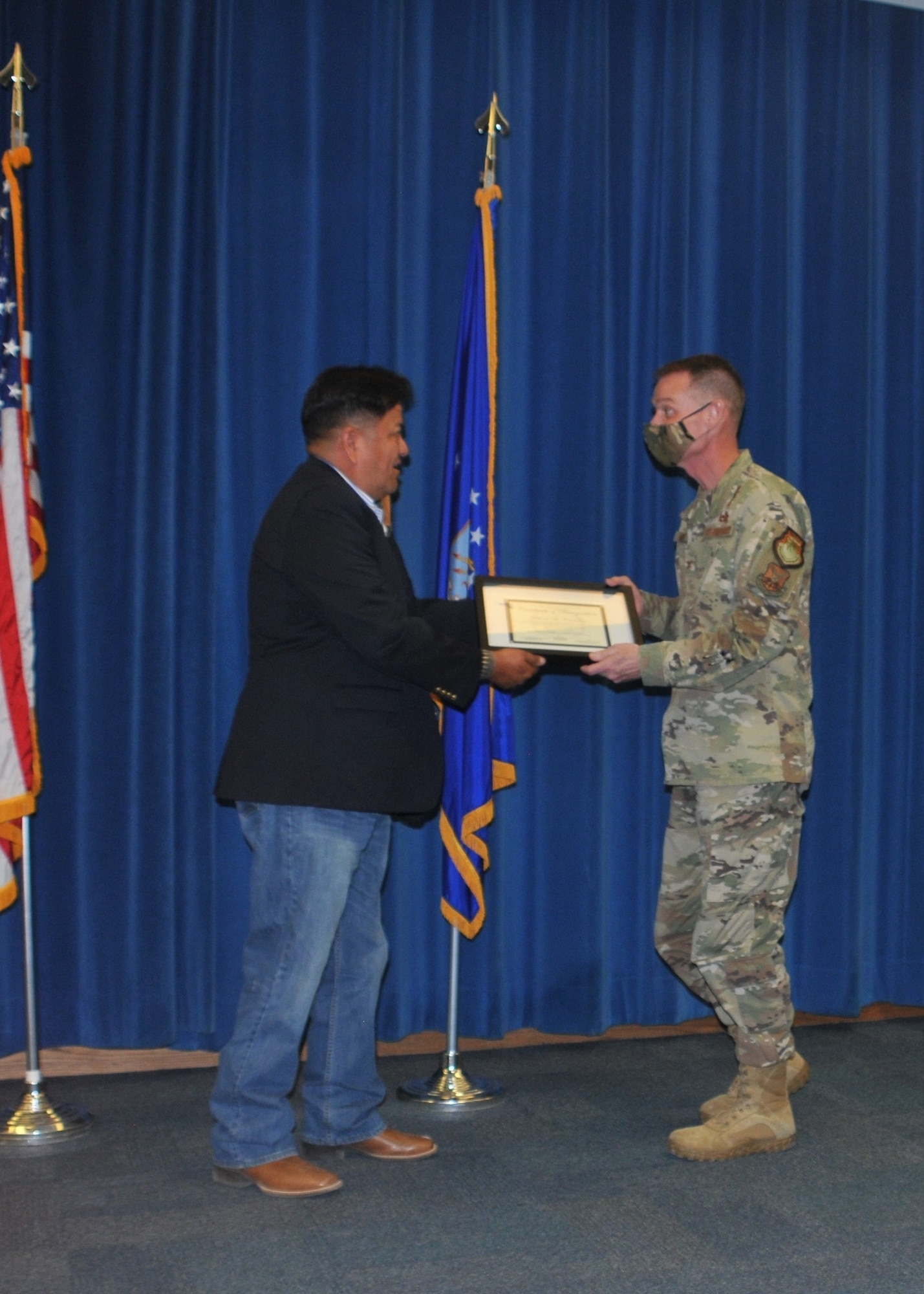 Native American man presents certificate to U.S. Air Force colonel.