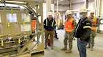 three men look at a fuel additive injection system