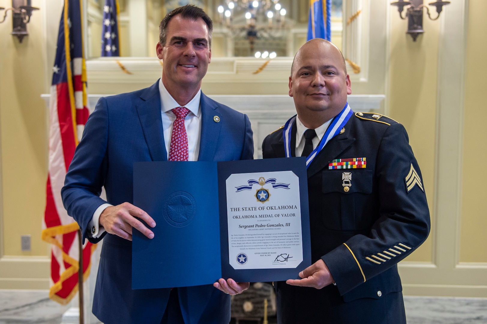 Kevin J. Stitt, governor of Oklahoma, poses with Oklahoma Army National Guard Sgt. Pedro Gonzales III after presenting him with the Oklahoma Medal of Valor during a ceremony at the Oklahoma State Capitol in Oklahoma City, May 18, 2021. The Oklahoma Medal of Valor is the state of Oklahoma’s highest award of honor presented to a member of a public safety agency or member of the public. (Oklahoma National Guard photo by Anthony Jones)