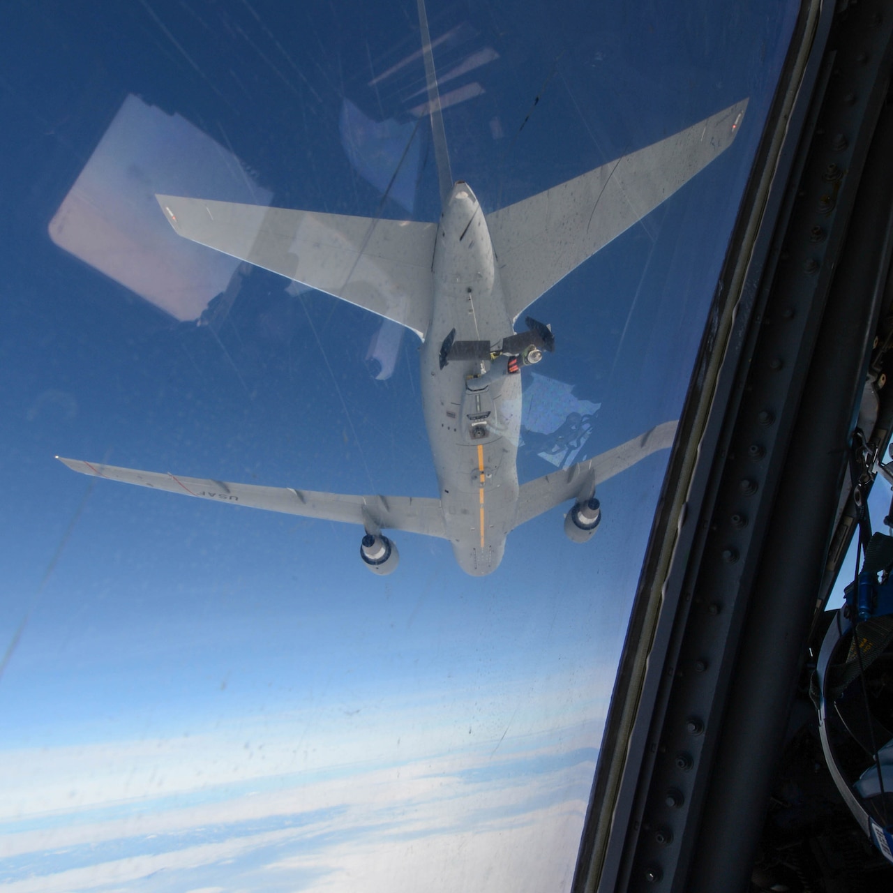 Another aircraft is visible through an aircraft window.