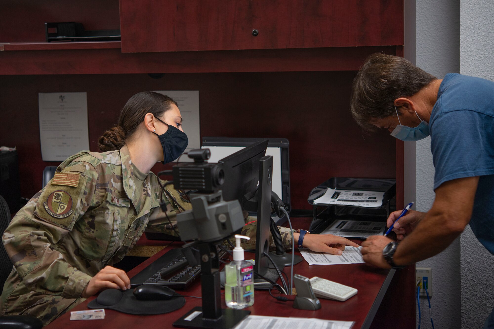 Airman 1st Class Jina Smith, 81st Force Support Squadron customer support apprentice, instructs the proper method to fill out a form inside the Sablich Center at Keesler Air Force Base, Mississippi, May 19, 2020. Smith went through basic military training during the height of the COVID-19 pandemic. (U.S. Air Force photo by Senior Airman Kimberly L. Mueller)