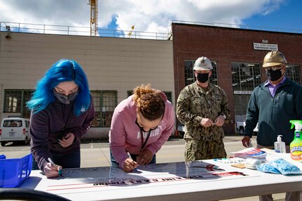 Puget Sound Naval Shipyard & Intermediate Maintenance Facility leaders and employees signed C.A.R.E. pledges and banners during two events May 18, 2021, at locations throughout the shipyard in Bremerton, Washington.