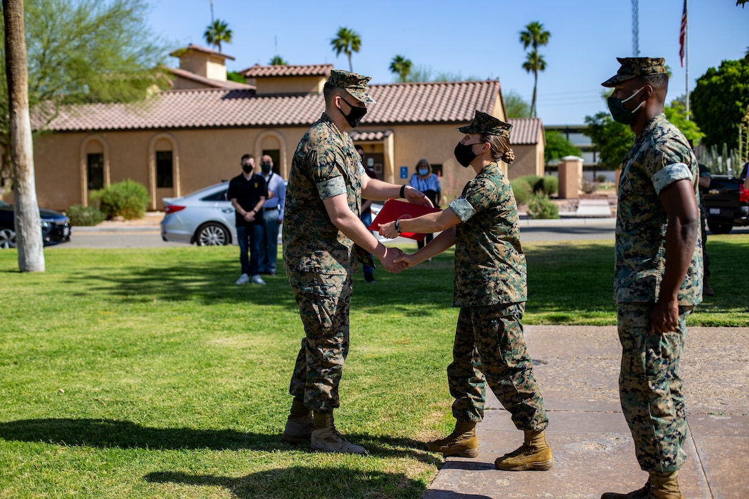 U.S. Marine Corps Cpl. Skylar Jacobson, an administration specialist with Headquarters and Headquarters Squadron (H&HS), re-enlists during a ceremony aboard Marine Corps Air Station Yuma on May 14, 2021.