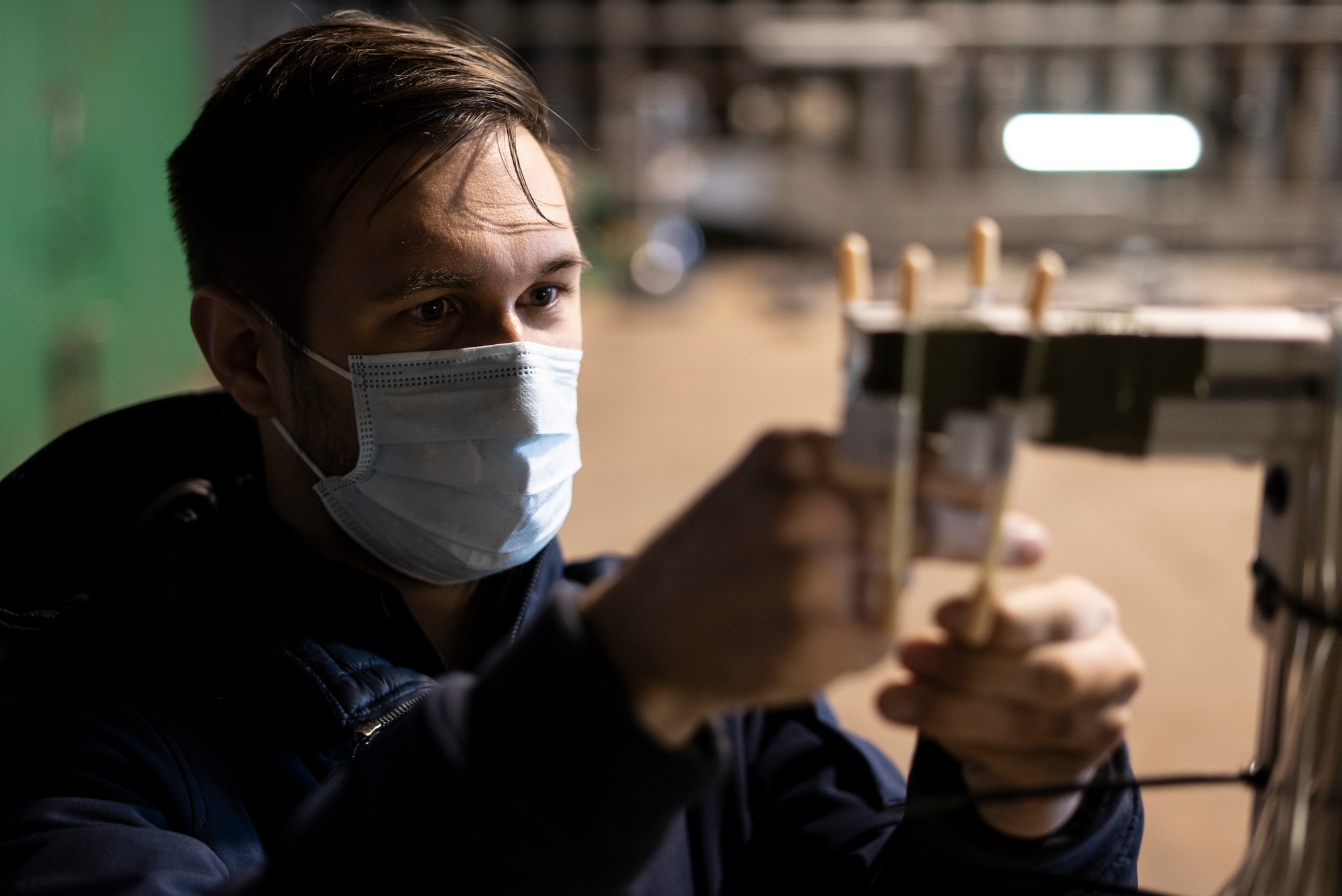 Ryan McNeilly, a hazard recognition technician stationed at Wright-Patterson Air Force Base, Ohio, sets up air sampling pumps prior to an F-35A Lightning II acoustic and emission test at Royal Air Force Lakenheath, England, May 4, 2021. The measurements taken during testing determine allowable noise and gaseous emissions exposure limits for pilots and maintenance personnel working inside the protective aircraft shelter. (U.S. Air Force photo by Senior Airman Jessi Monte)