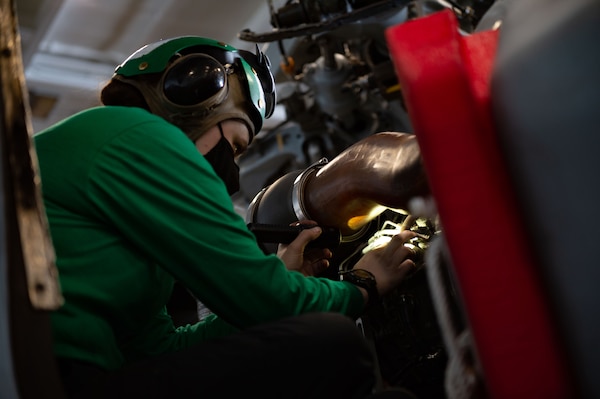 Aviation Machinist Mate 2nd Class Laurel Rinehart, from Great Falls, Montana, assigned to the "Dragon Slayers" of Helicopter Sea Combat Squadron (HSC) 11, inspects the engine of an MH-60S Sea Hawk helicopter for corrosion in the hangar bay of the Nimitz-class aircraft carrier USS Harry S. Truman (CVN 75) during sea trials after completing an extended carrier incremental availability.