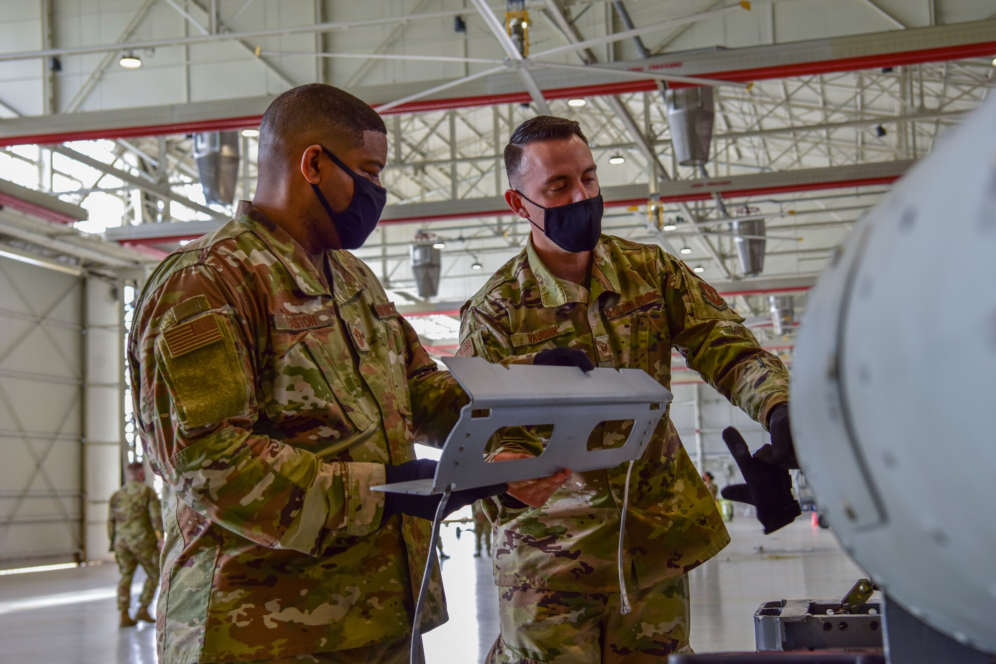 Chief Master Sgt. Phillip Easton, U.S. European Command senior enlisted leader, left, and U.S. Air Force Staff Sgt. Kyle Vaughn, 31st Munitions Squadron conventional munitions technician, install a bomb component during a bomb build at Aviano Air Base, Italy, May 13, 2021. During his visit Easton saw practical projects with a more hands on approach. During the bomb build Easton helped install various pieces to the munition with the help of Munitions Squadron Airmen while getting to know them and their job. (U.S. Air Force photo by Senior Airman Jessica Blair)
