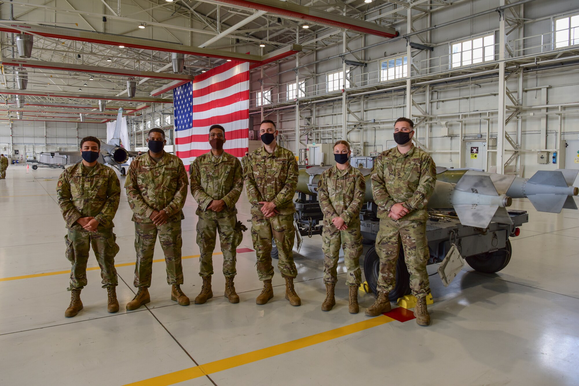 Chief Master Sgt. Phillip Easton, U.S. European Command senior enlisted leader, poses for a group photo with Airmen from the 31st Munitions Squadron at Aviano Air Base, Italy, May 13, 2021. Easton participated in a bomb build during his visit to get a more hands on approach. During the bomb build Easton helped install various components to the weapon with the help of Munitions Squadron Airmen while getting to know them and their job. (U.S. Air Force photo by Senior Airman Jessica Blair)