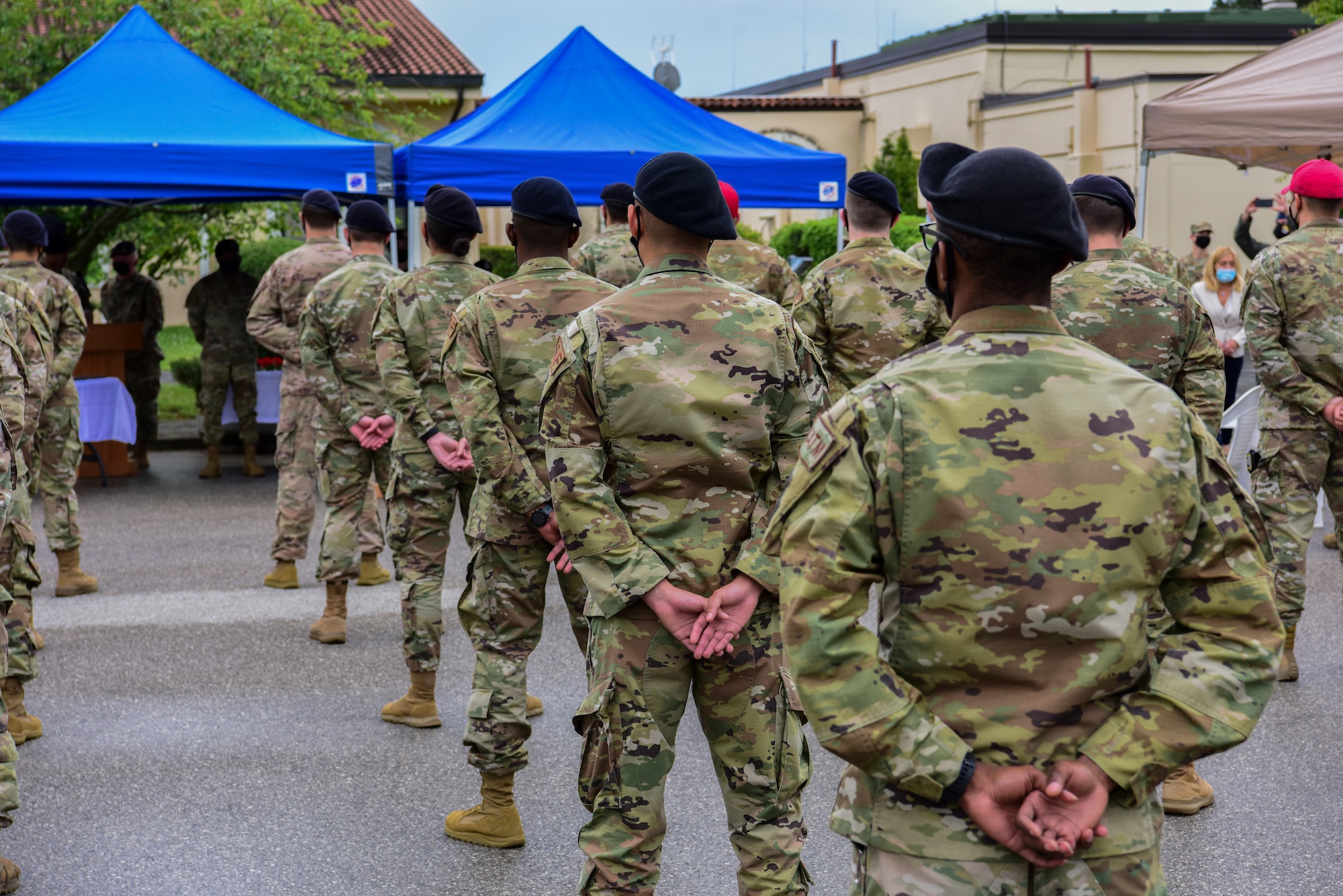 A group of 31st Security Forces defenders stand in formation during a memorial ceremony at Aviano Air Base, Italy, May 14, 2021. The national Police Week closing ceremony is a memorial service to honor the 26 defenders and Office of Special Investigations agents who paid the ultimate sacrifice since 2001. During the ceremony there was a formation of defenders, Humvees on display, and a photo and rose bearing session in memory of them. (U.S. Air Force photo by Senior Airman Jessica Blair)