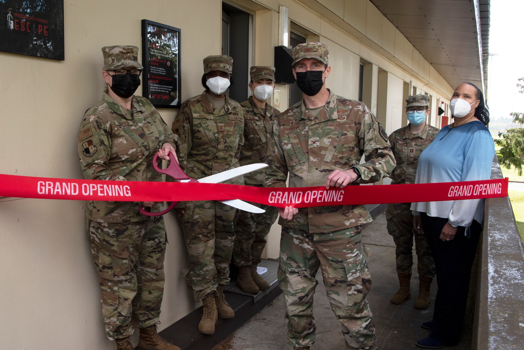 U.S. Air Force Col. David Epperson, 52nd Fighter Wing commander (center), U.S. Air Force Chief Master Sgt. Stephanie Cates, 52nd FW command chief (far left), and members of the Saber chapel team cut a ceremonial ribbon to officially open “Spangdahlem’s Amazing Escape” rooms at Spangdahlem Air Base, Germany, May 14, 2021. The chapel staff worked on the escape rooms for more than nine months to have them ready to open in 2021. (U.S. Air Force photo by Tech. Sgt. Tony Plyler)