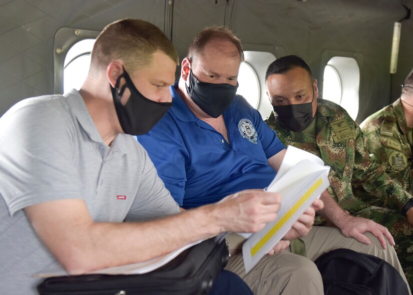 Joe Kidwell, left, the Colombian Central Case Manager at U.S. Army Security Assistance Command – New Cumberland, along with Jason King, center, the USASAC Colombian Country Program Manager, and their Colombian military counterpart, discuss foreign military sales cases during flight to see the Tolemaida Air Base, 6 April 2021.