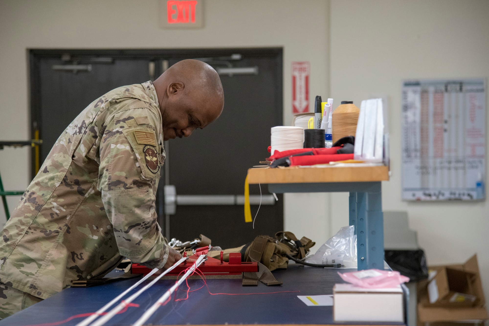 Tech. Sgt. Tyree Leverette, 403rd Operational Support Squadron aircrew flight equipment technician at Keesler Air Force Base, Miss., fastens the cords of a  BA-30 Low Profile Parachute system to an apparatus that facilitates the assembly and packing of the parachute into its backpack May 2, 2021. Gradually, the Air Force is making a branch-wide transition to the BA-30s for certain aircraft. (U.S. Air Force by Staff Sgt. Kristen Pittman)