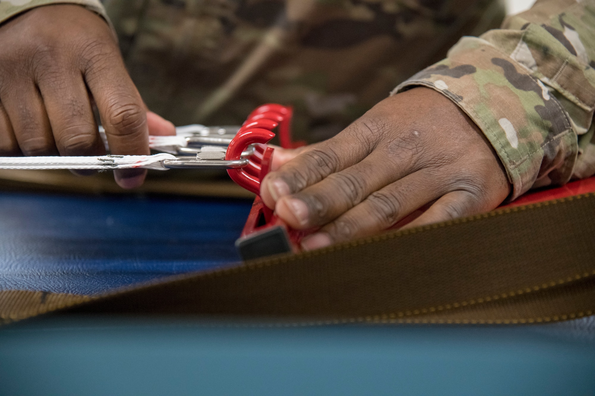 Tech. Sgt. Tyree Leverette, 403rd Operational Support Squadron aircrew flight equipment technician at Keesler Air Force Base, Miss., fastens the cords of a  BA-30 Low Profile Parachute system to an apparatus that facilitates the assembly and packing of the parachute into its backpack May 2, 2021. Gradually, the Air Force is making a branch-wide transition to the BA-30s for certain aircraft. (U.S. Air Force by Staff Sgt. Kristen Pittman)