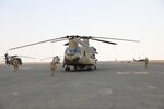 Task Force Phoenix personnel walk out to their aircraft on flight line at Camp Buehring, Kuwait.