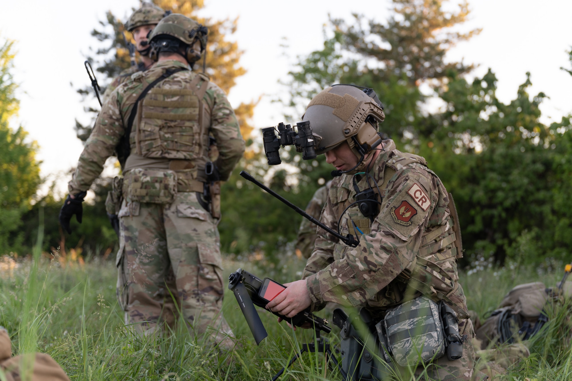 An Airman setting up communications equipment in a field.