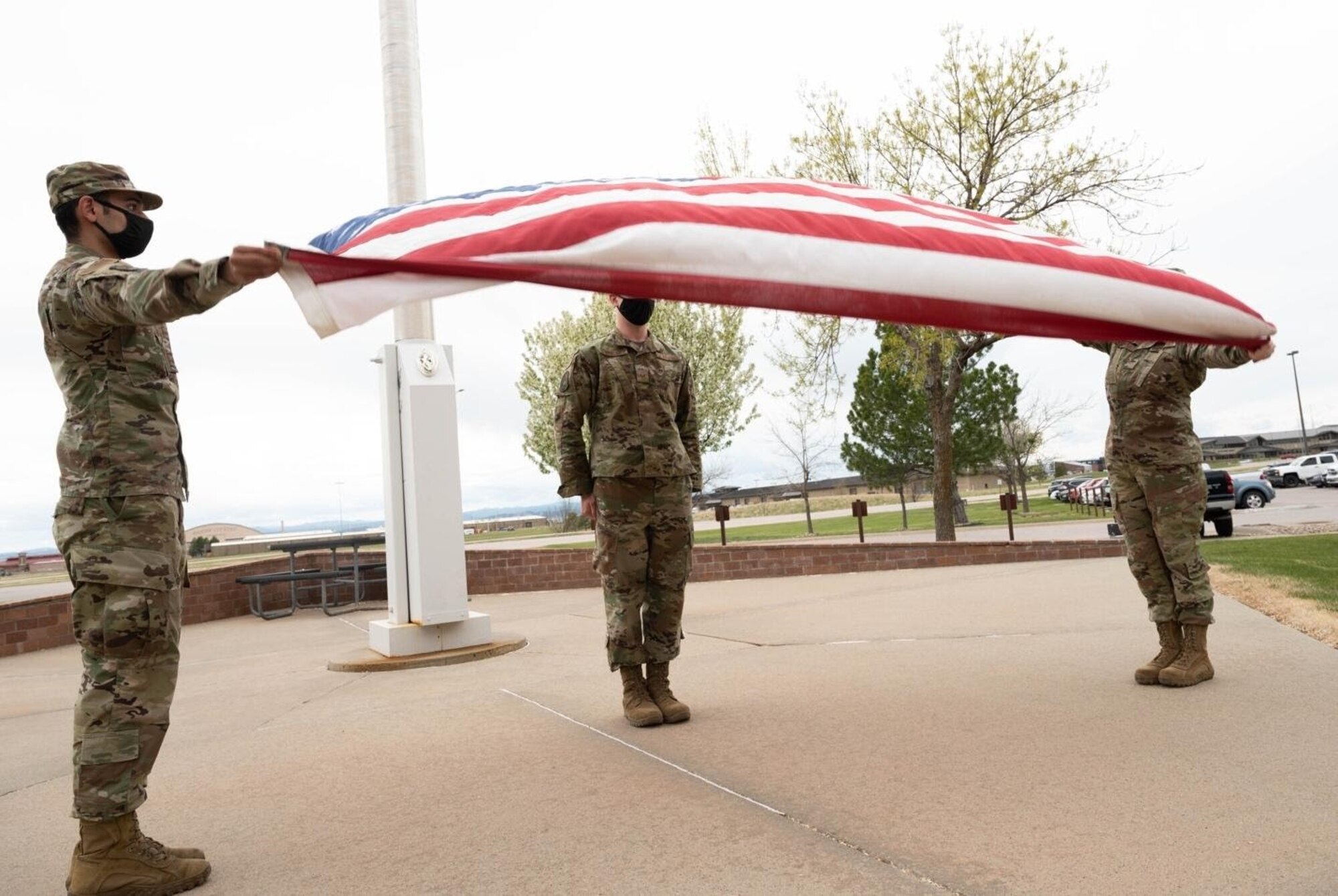 Airmen fold the flag during a retreat ceremony, signaling the end of National Police Week at Ellsworth Air Force Base, S.D., May 14, 2021.