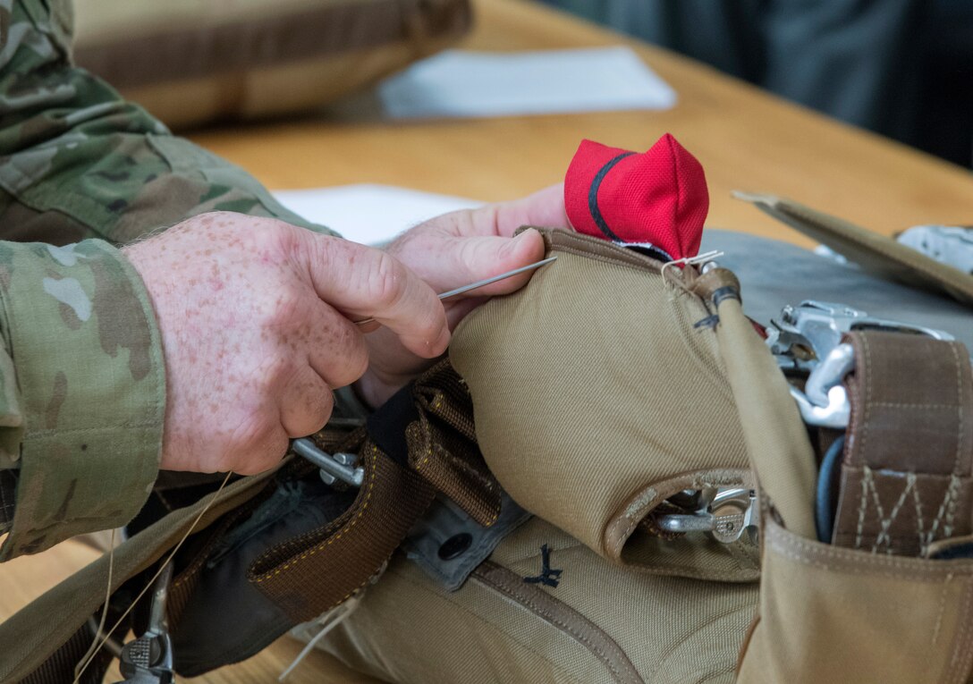 Tech. Sgt. Ronald Patton, aircrew flight equipment technician for the 403rd Operations Support Squadron at Keesler Air Force Base, Miss., reinforces a BA-30 Low Profile Parachute system April 29, 2021. Patton repairs flight equipment to ensure it is safe to use in the event of an in-flight emergency. (U.S. Air Force photo by Staff Sgt. Kristen Pittman)