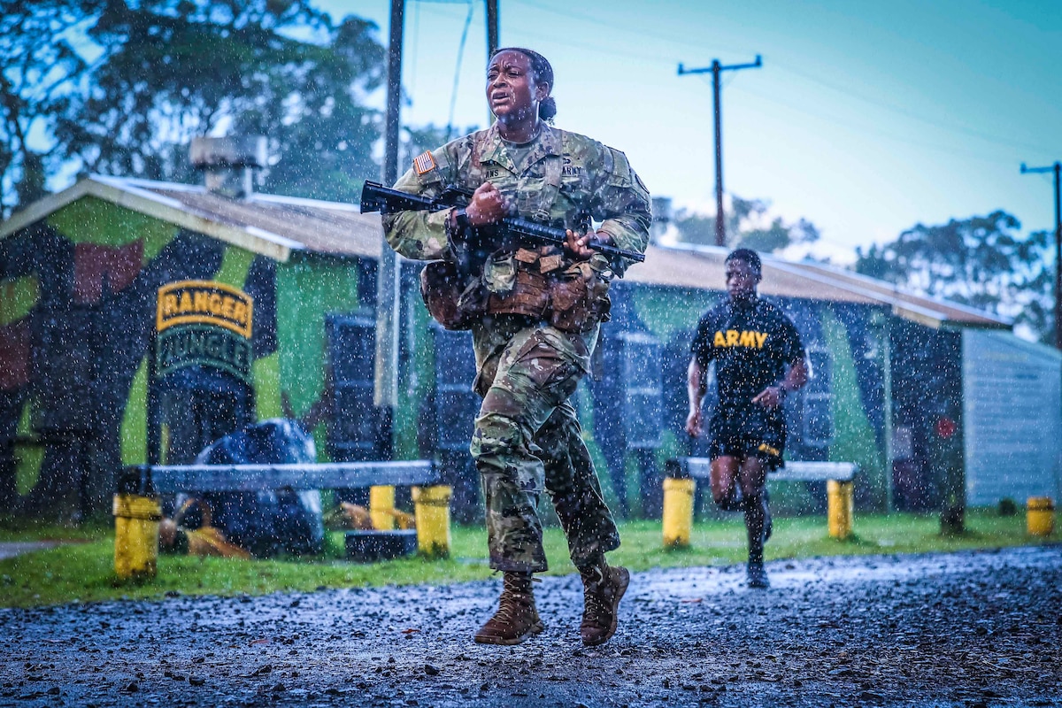 A soldier carries a weapon while running in the rain.
