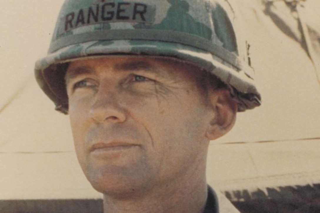 A man wearing a helmet looks to the left.