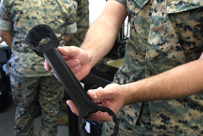 U.S. Marine Cpl. Tyler Anglin from 1st Maintenance Battalion holds a 3D printed universal load stud wrench during a demonstration event at Marine Corps Tactical Systems Support Activity, on Camp Pendleton, Calif., April 5-9, 2021. MCTSSA hosted a team of design experts who tested the network connectivity of the portable expeditionary fabrication lab, a self-contained, transportable additive manufacturing lab that can deploy with battalion-level Marine maintenance units.