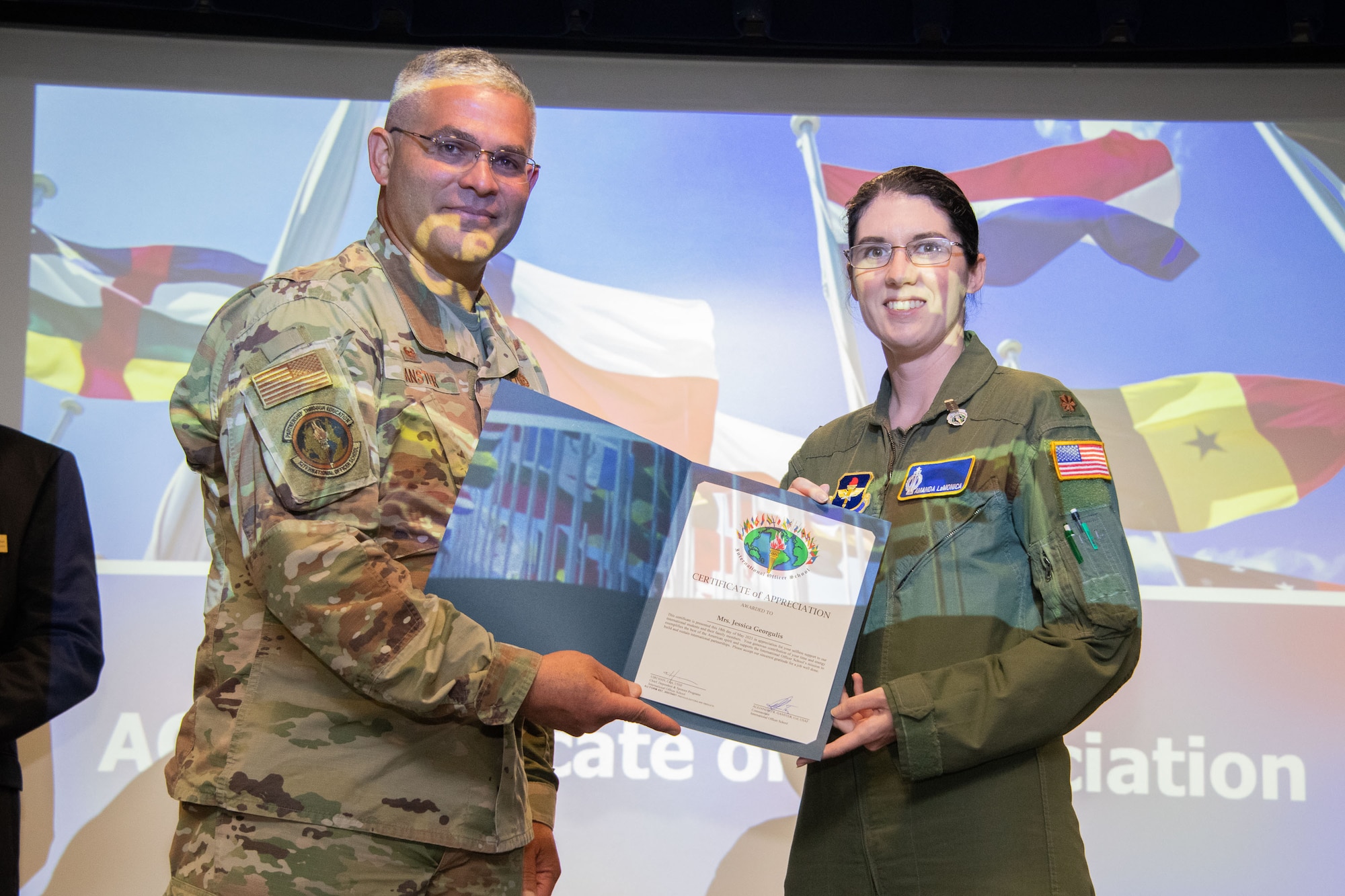 International Officer School Commandant and Air University International Affairs Director Col. Alex Ganster presents a certificate of appreciation to Maj. Amanda LaMonica at Husband Auditorium, Maxwell Air Force Base, Alabama, May 18, 2021.