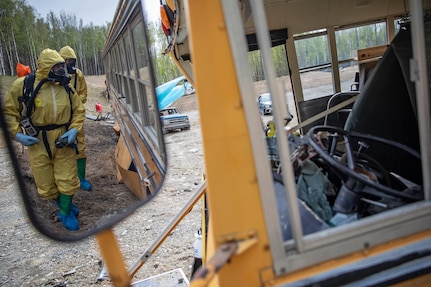 Tech. Sgt. David Hurst and Staff Sgt. Logan Gladfeather, team members of the 52nd Civil Support Team, Ohio National Guard, survey a bus at the Mat-Su Fire Training Center in Wasilla, Alaska, May 19, during Exercise ORCA 2021. ORCA is a chemical, biological, radioactive, nuclear threats response exercise designed for participants to provide support in the aftermath of hazardous materials incidents. ORCA tests interoperability between agencies, increases opportunities for working relationships, and practices requests for assistance methods. Approximately 250 National Guardsmen from CST units in Alaska, California, Connecticut, Colorado, Idaho, Ohio, Oregon, Rhode Island, South Carolina, South Dakota, Washington, and Wisconsin are in Alaska to participate in Exercise ORCA 2021. Numerous support units and civilian agencies participated in the exercise as well. (U.S. Army National Guard photo by Edward Eagerton)